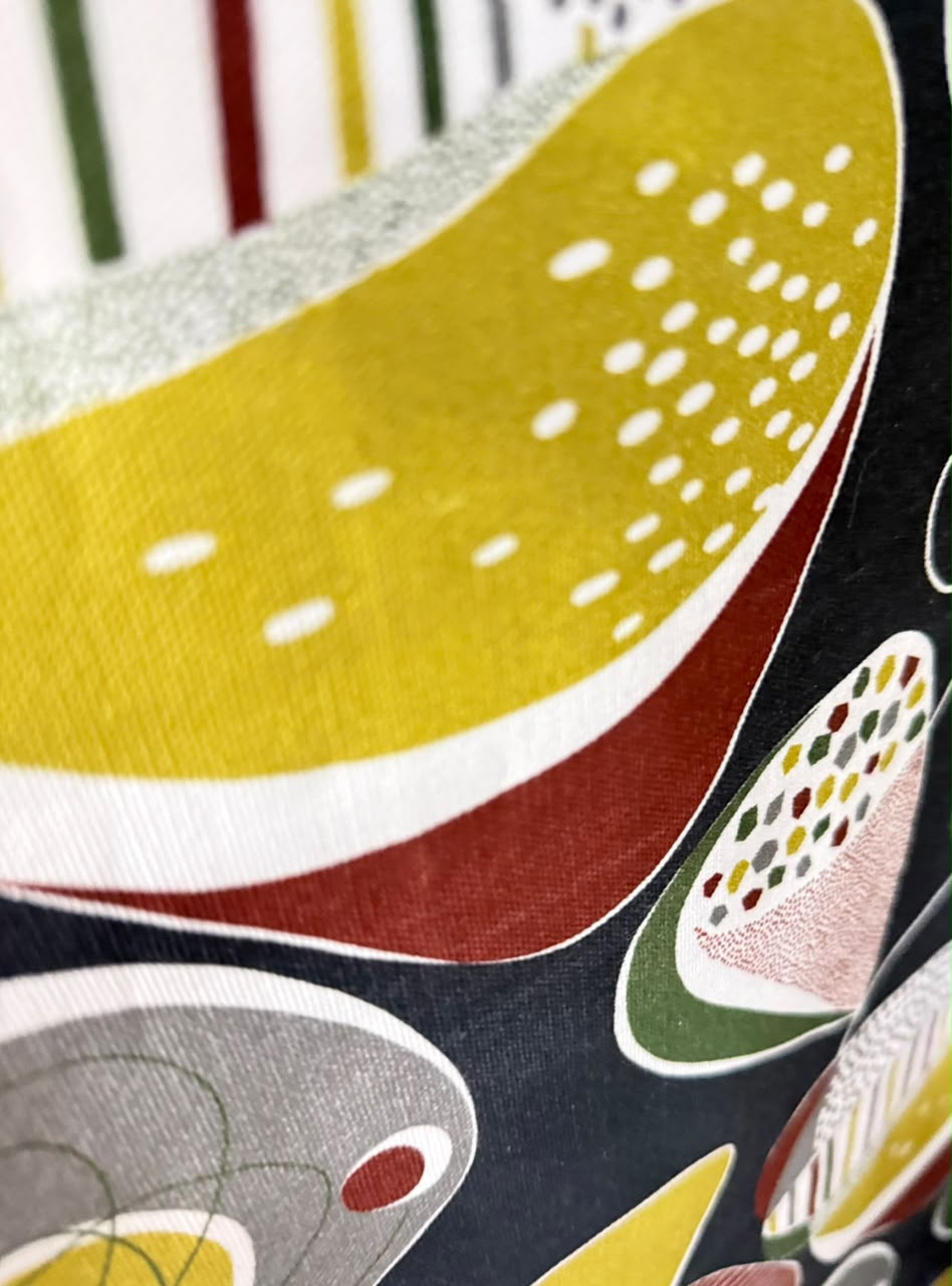 Detail of a warm yellow, rust and black fabric print