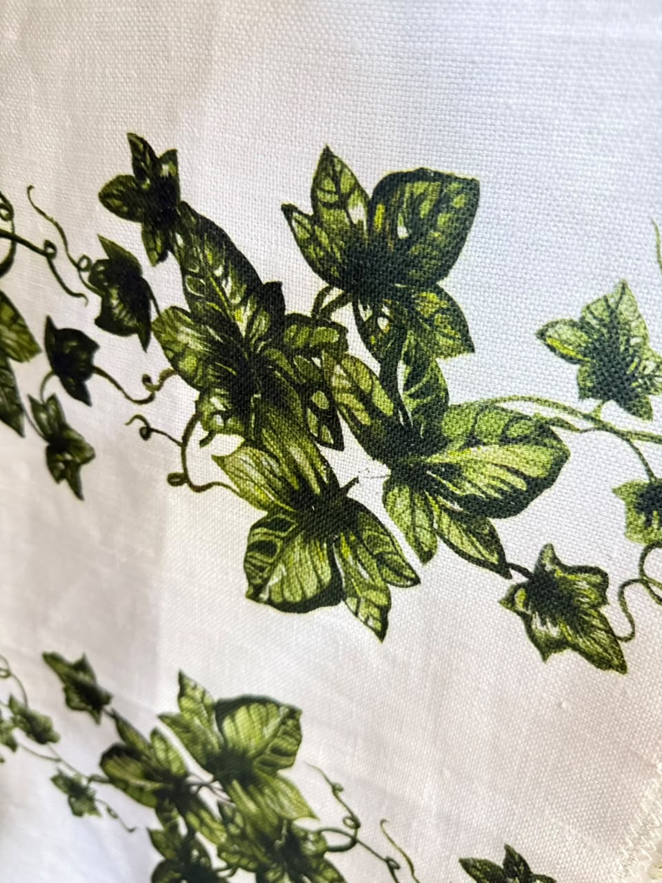 Green botanical motifs on a light fabric